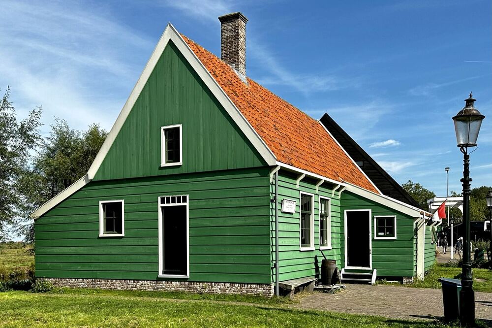 Een groen houten Zaans huis met rode dakpannen op de Zaanse Schans